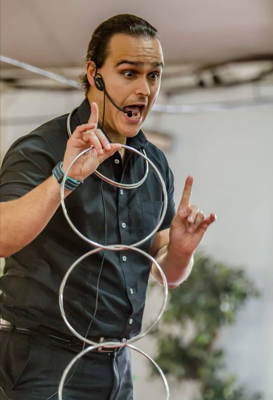 Magician performing with three rings while engaging the audience