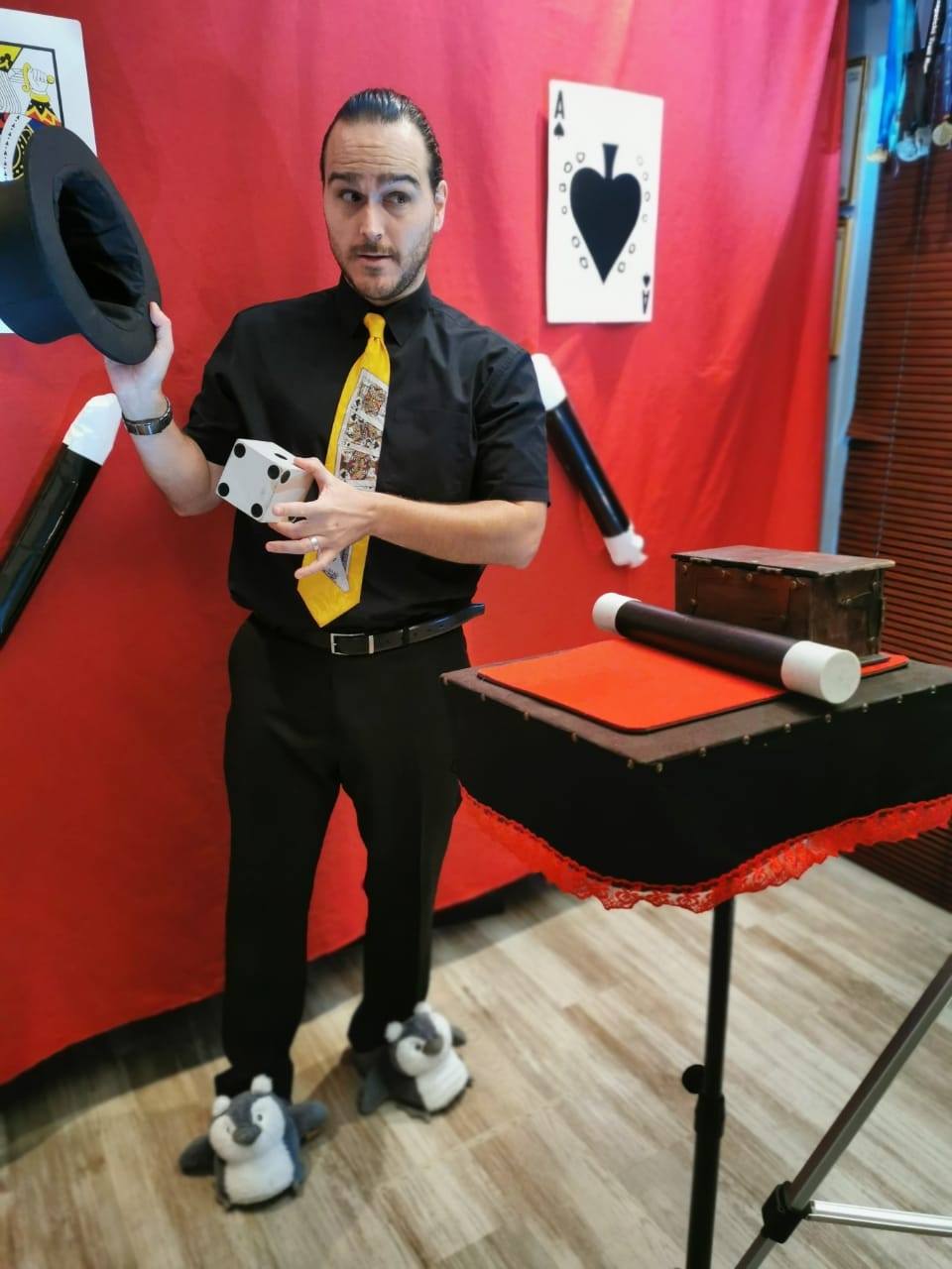 Magician in black with a top hat performing tricks