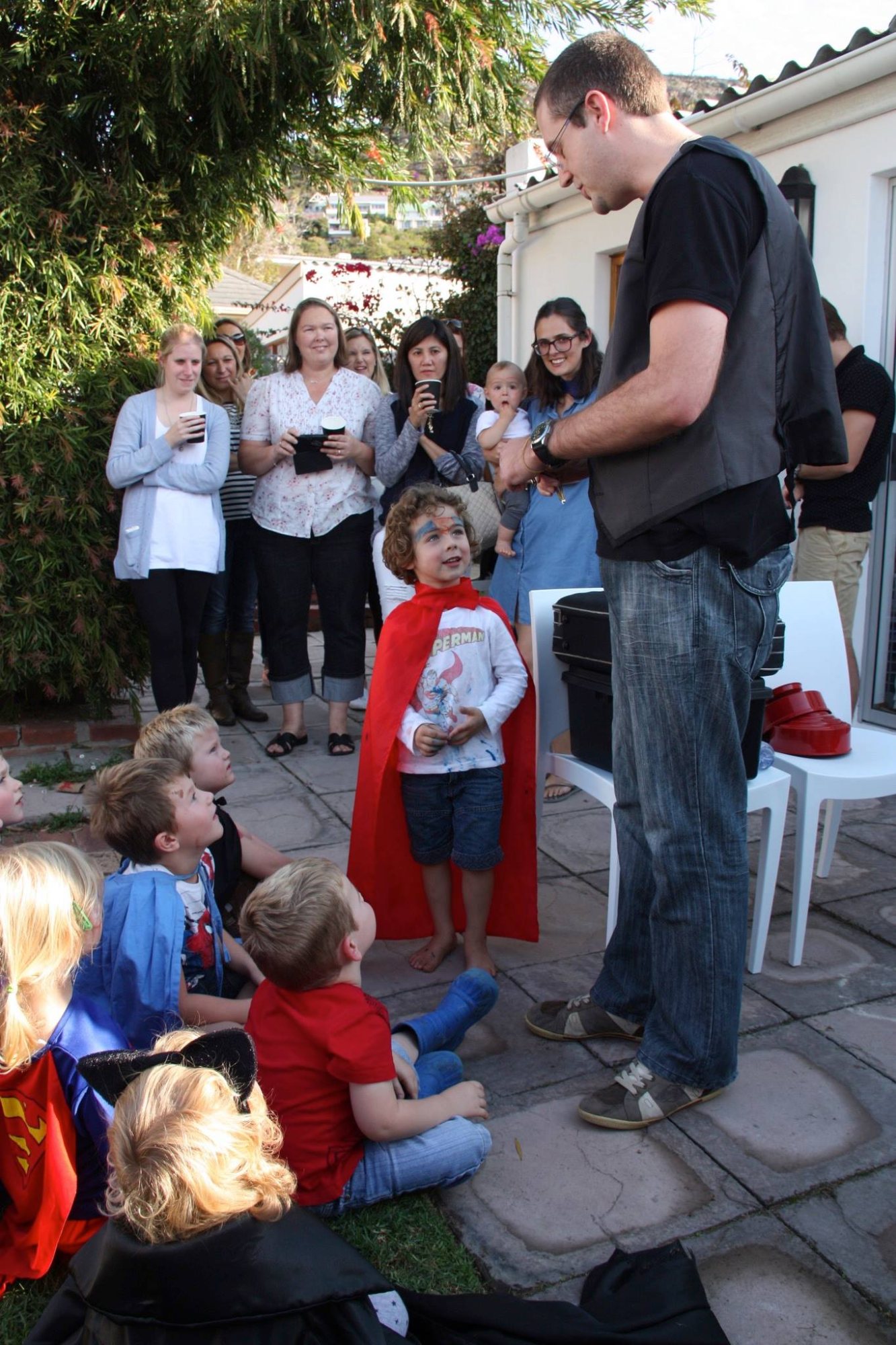 Magician performing for children at a backyard party.