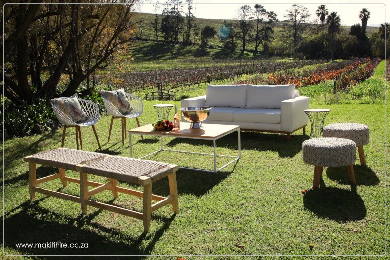 Outdoor lounge setup with sofa and chairs in vineyard