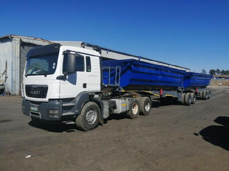 White MAN truck with blue side tipper trailer