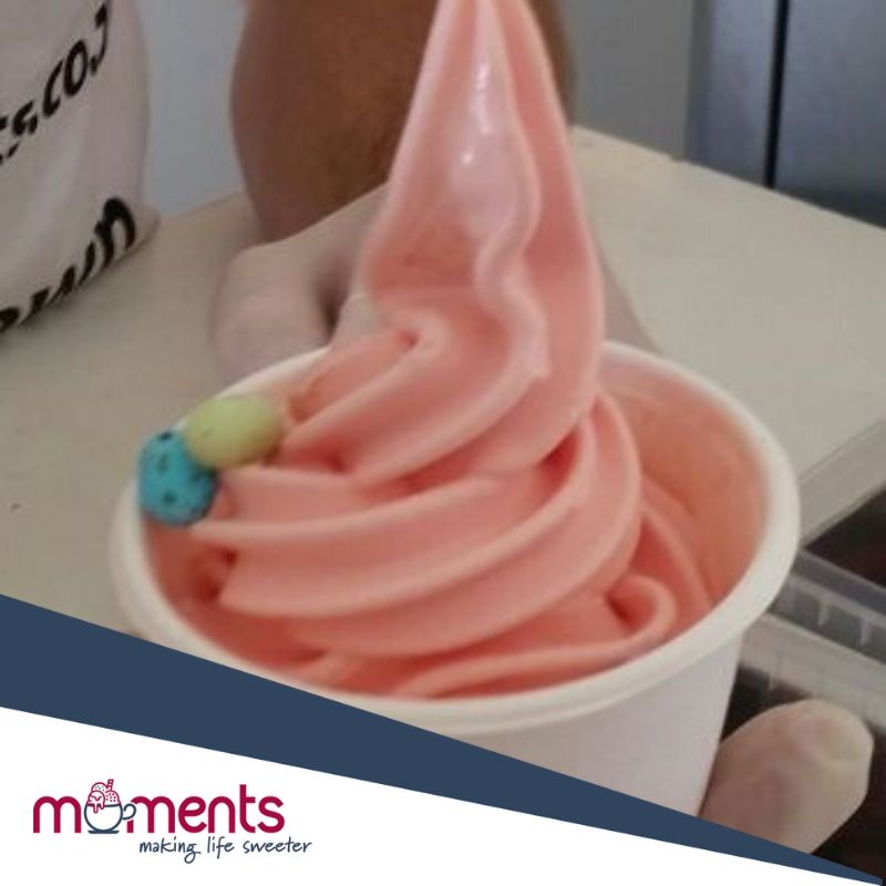 Cup of pink soft serve ice cream with a decorative topping.
