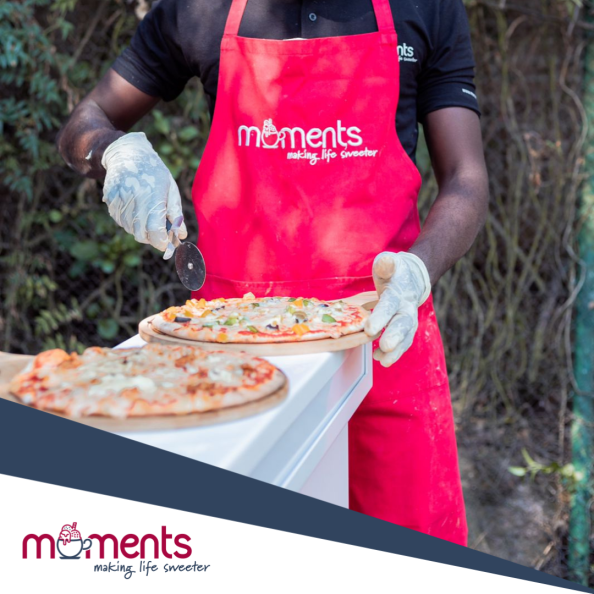 Staff member slicing pizza at an event