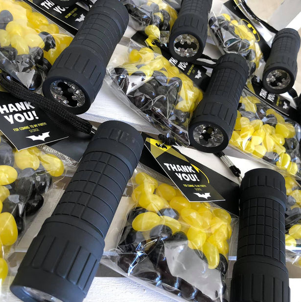 Party favour sets with black flashlights and yellow candy bags.