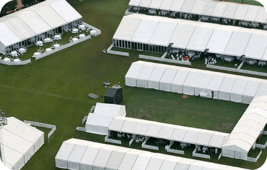Aerial view of multiple marquee tents arranged on a green field