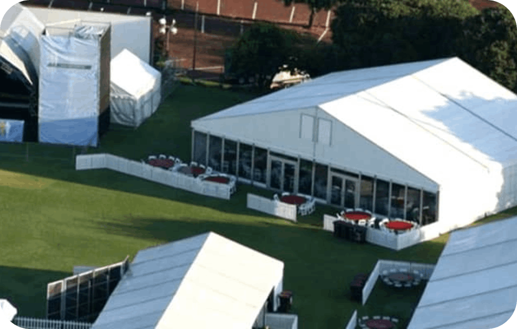 Large white marquee tents set up on green grass