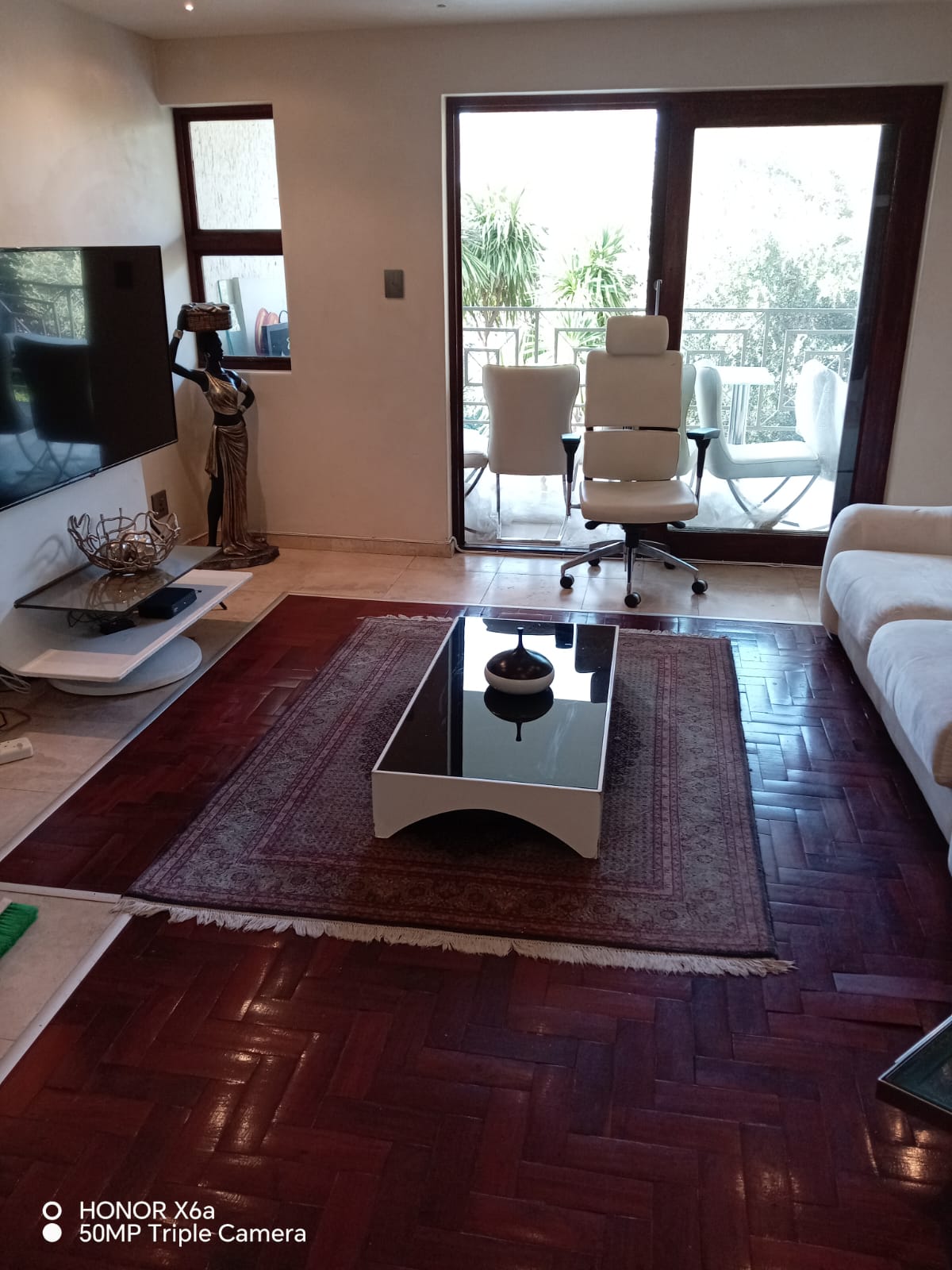 Modern lounge with a white sofa, coffee table, and natural light.