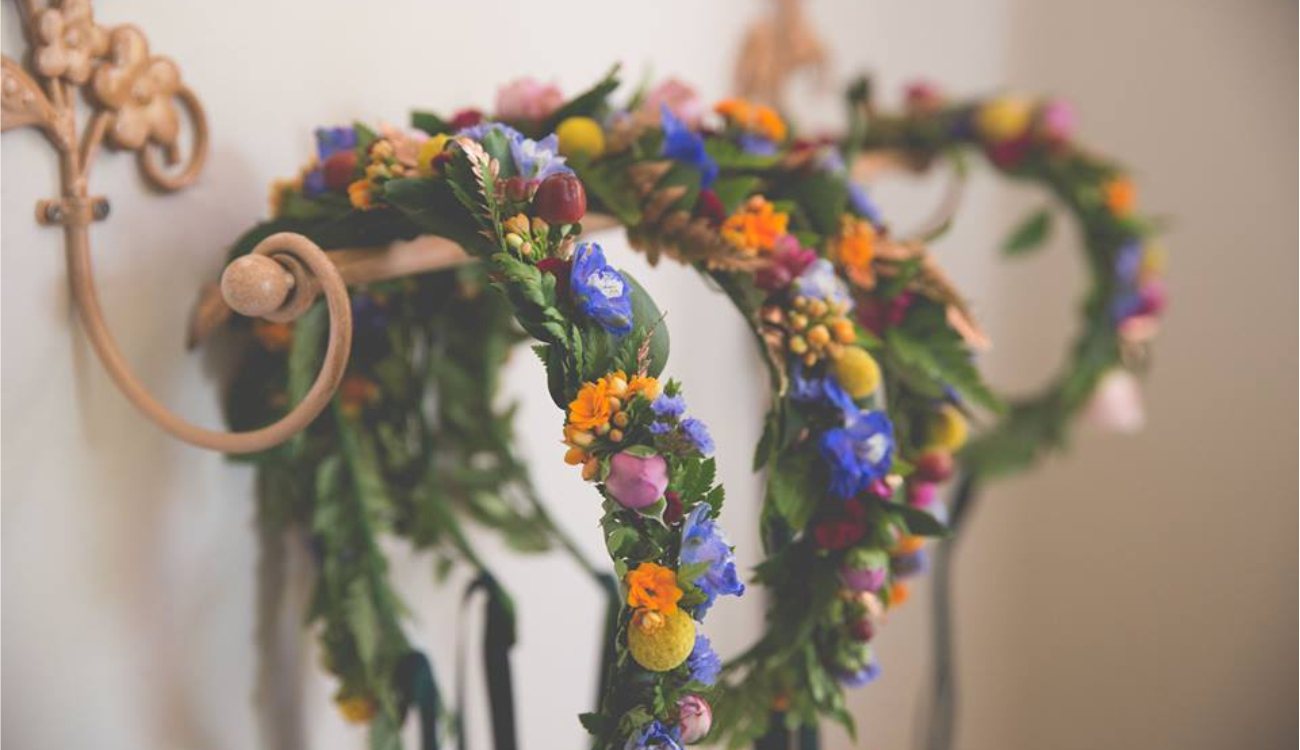 Colorful floral crowns hanging on a wall.
