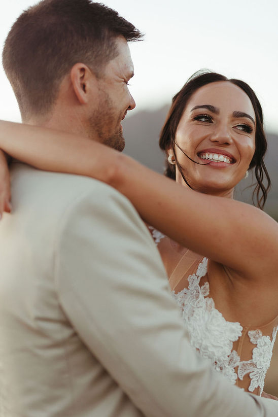 A couple in wedding attire embracing with smiles