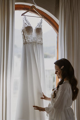 Bridal gown hanging by a window