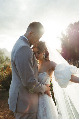 Bride and groom embracing in a scenic outdoor setting