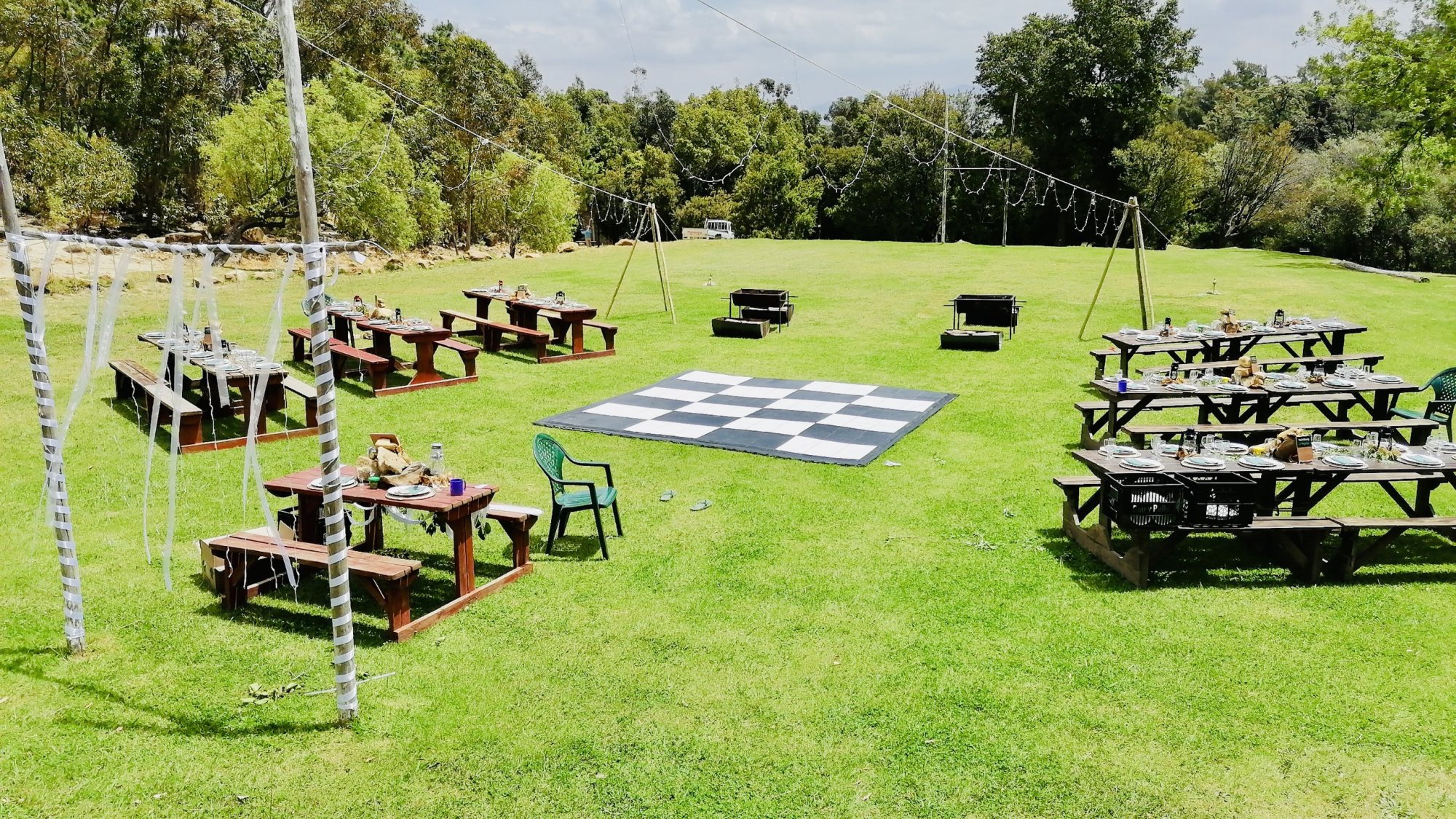 Outdoor event area with picnic tables and checkered flooring