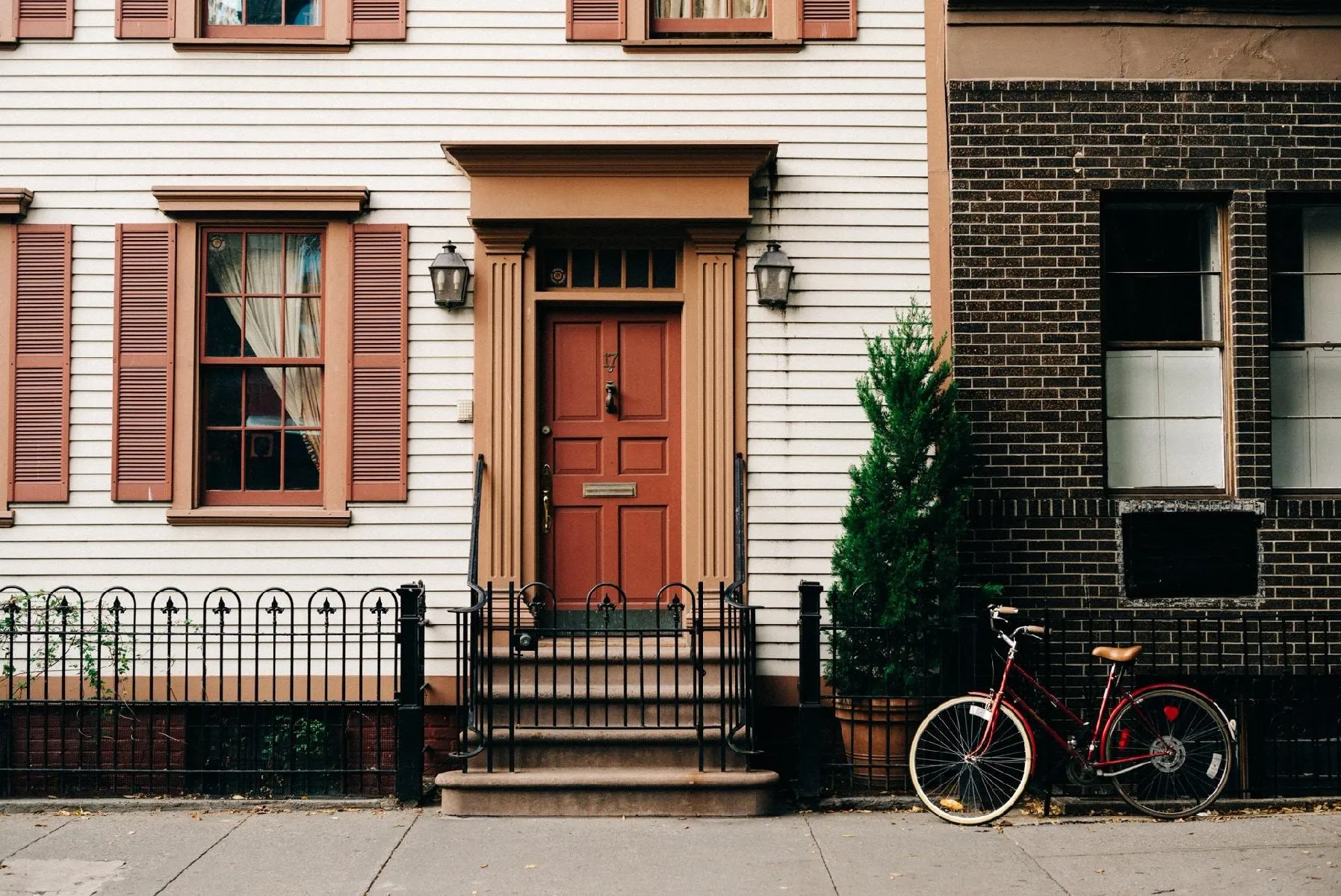 Entrance of a home with brick wall, bike, and greenery