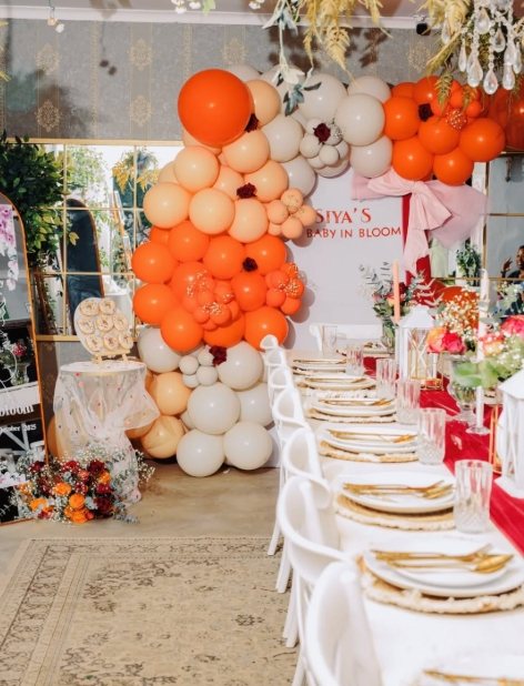 Colorful balloon installation in an event space with a decorated table