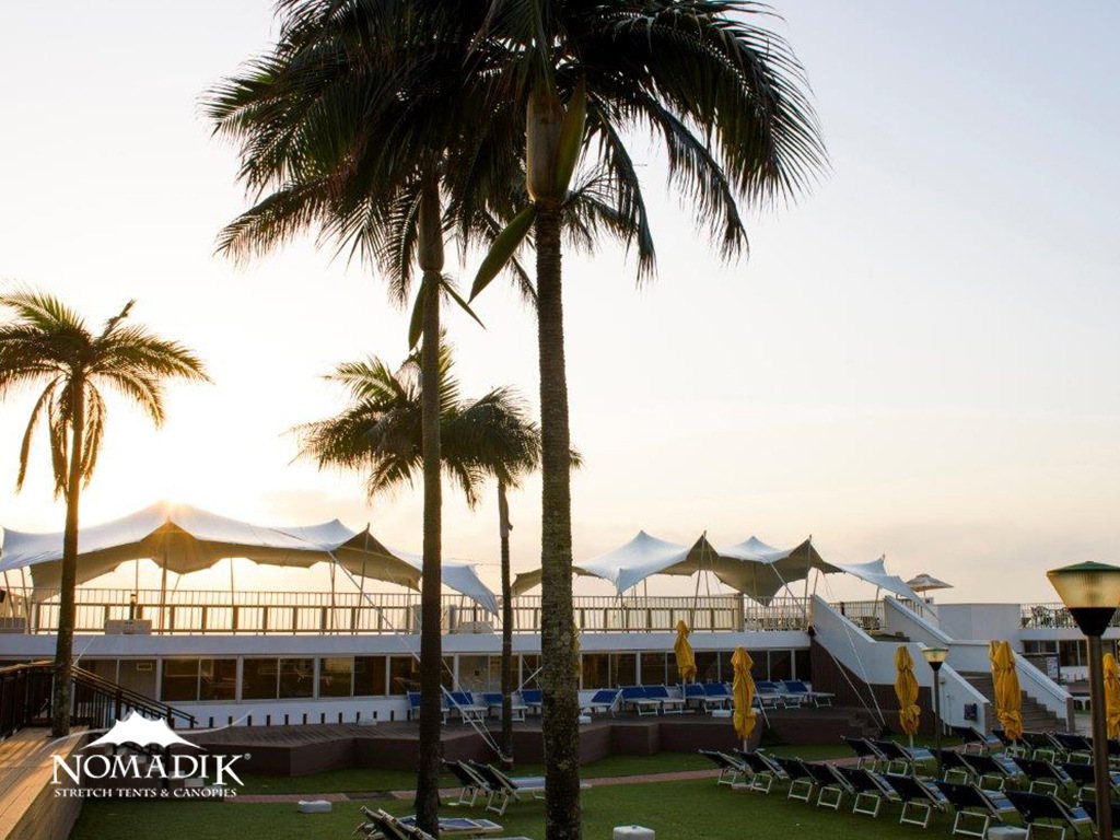 White stretch tents set up in an outdoor venue
