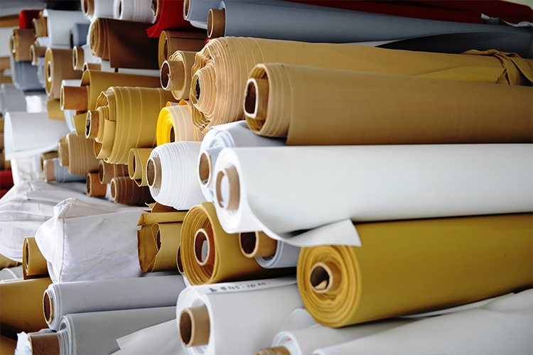 Stacked rolls of various fabric colors