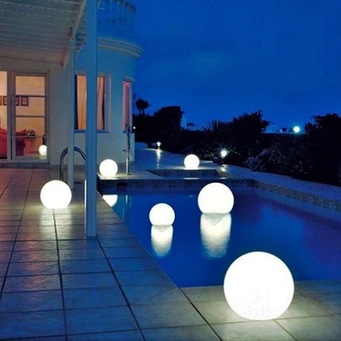 Floating illuminated orbs in a pool at night