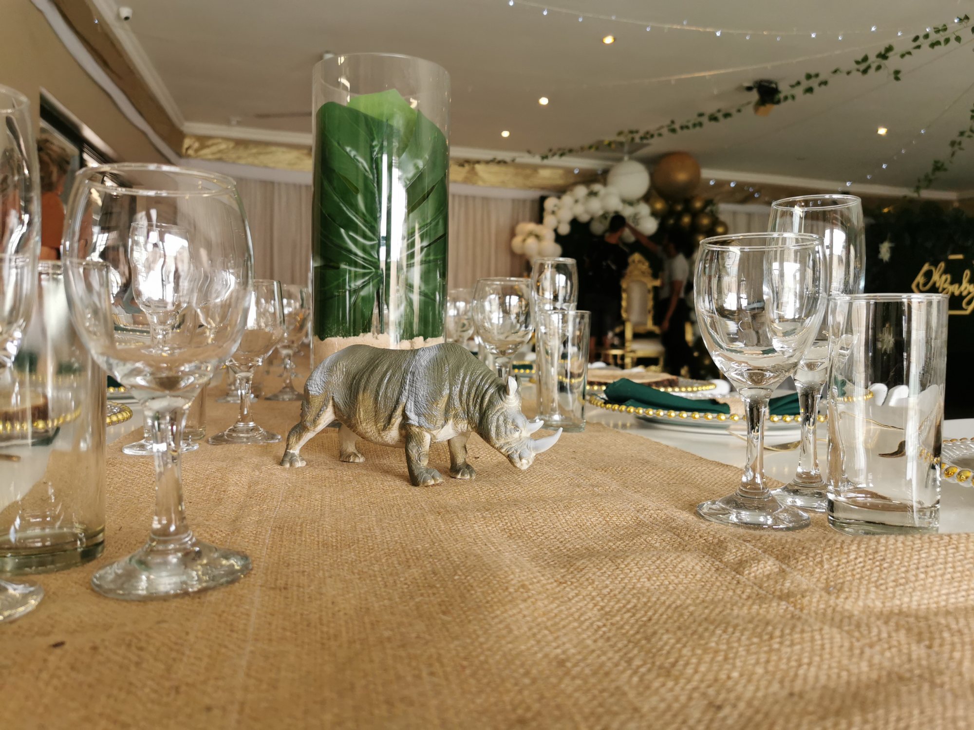 Themed table with a rhino figurine and green decor