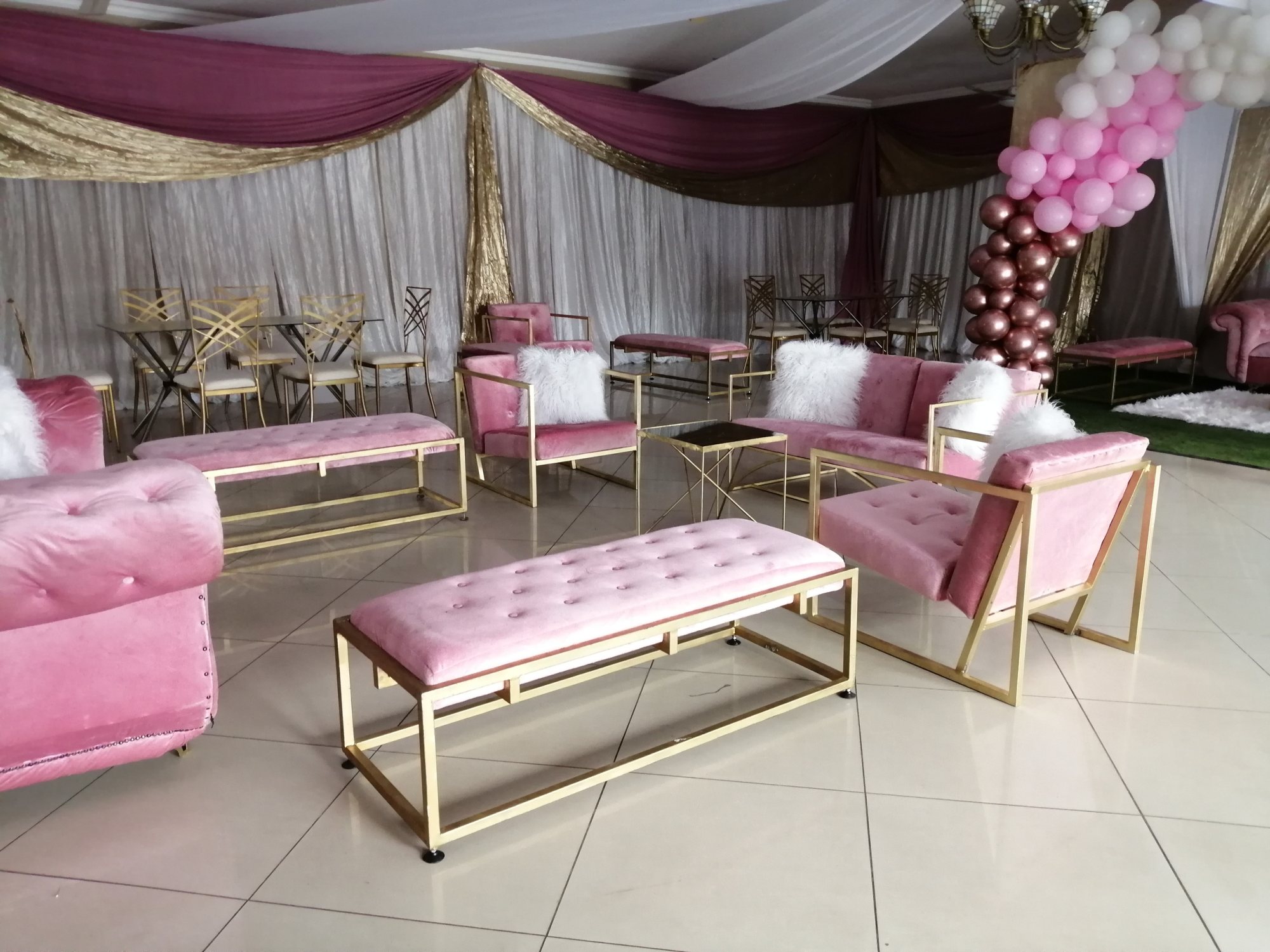 Pink lounge furniture with gold accents in an event space.