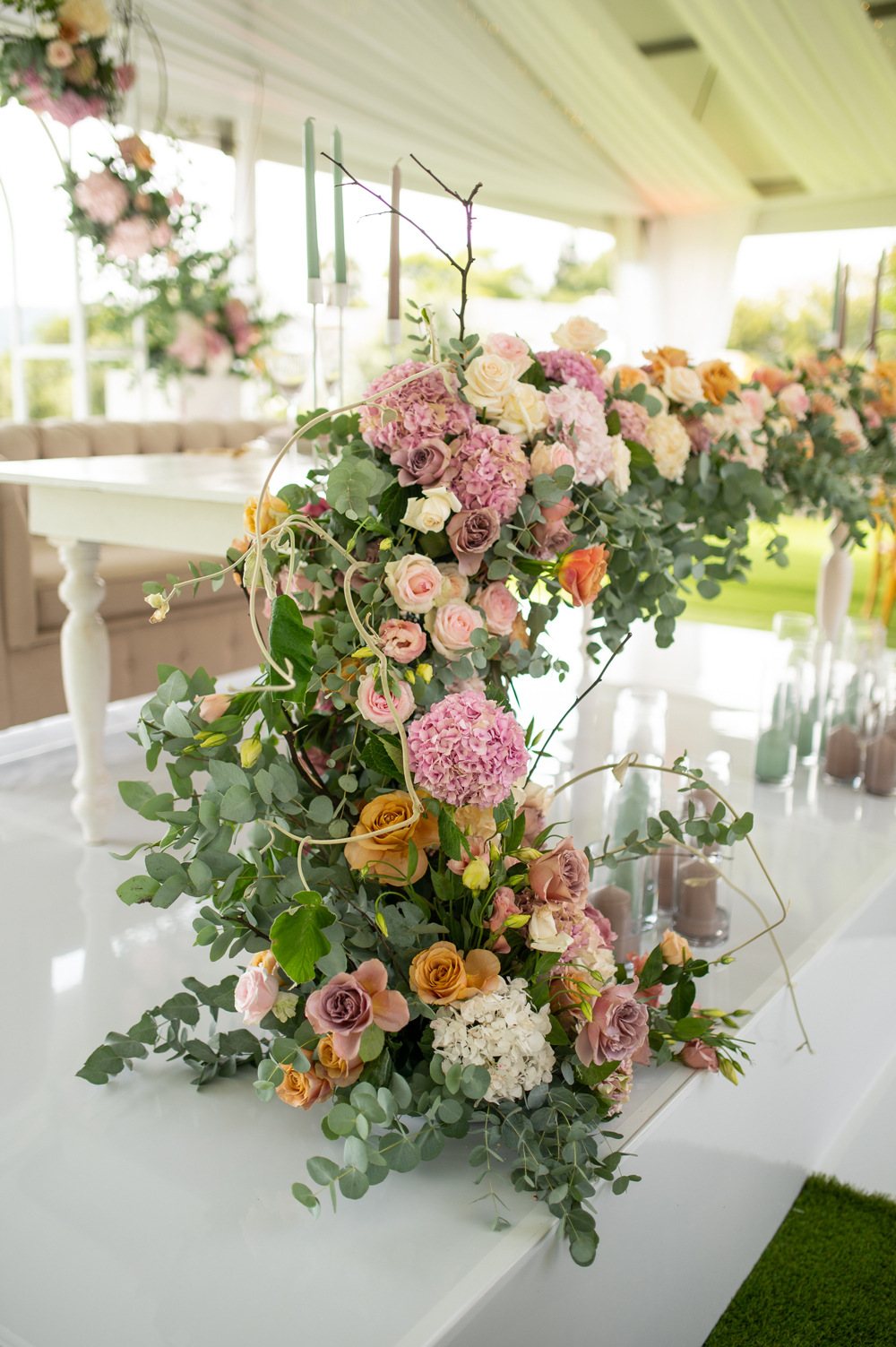 Floral arrangement with pink, orange, and white flowers on a table.