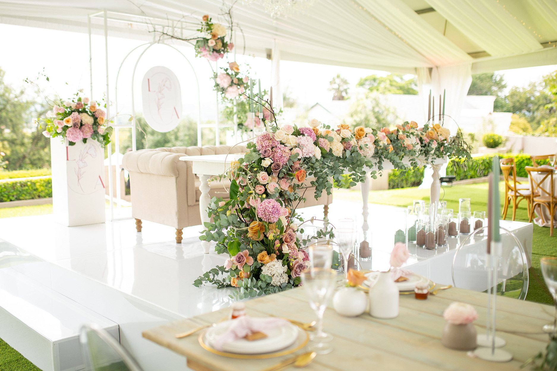 Floral lounge setup with elegant furniture and greenery