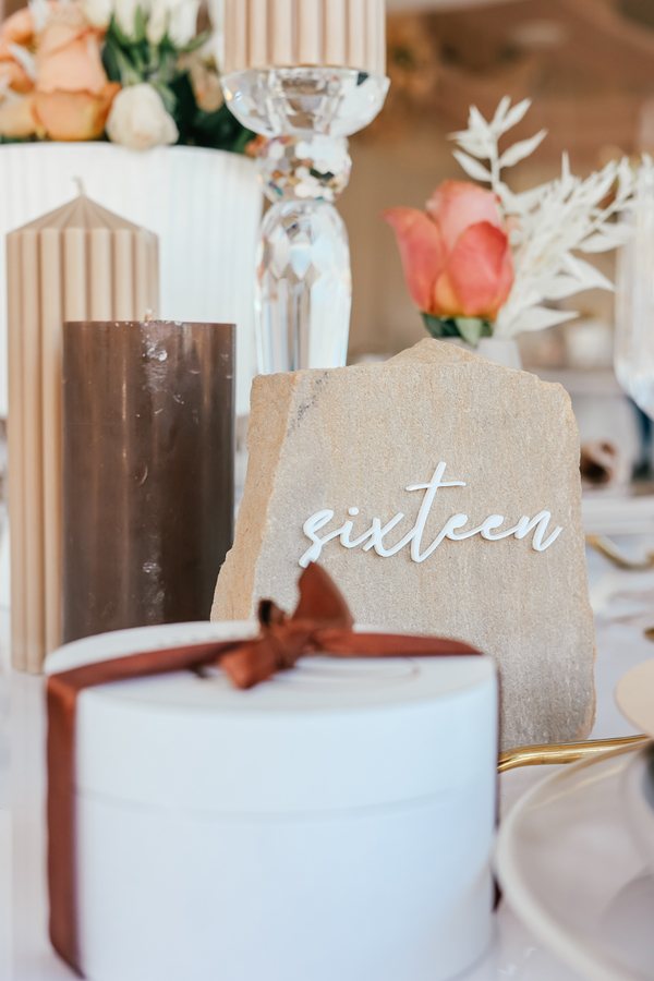 Close-up of table number sixteen on a decorative stone.