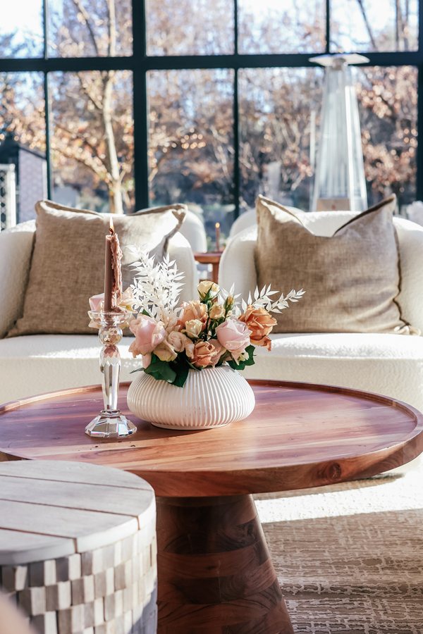 Wooden table with floral arrangement and decor in lounge area
