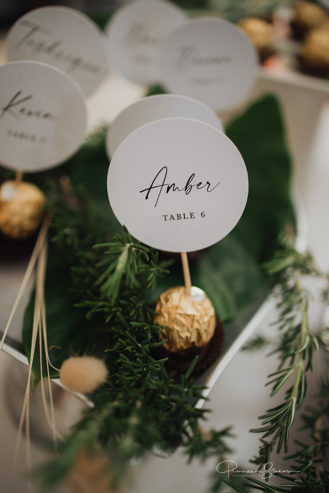 Stylish place cards on greenery for table settings.