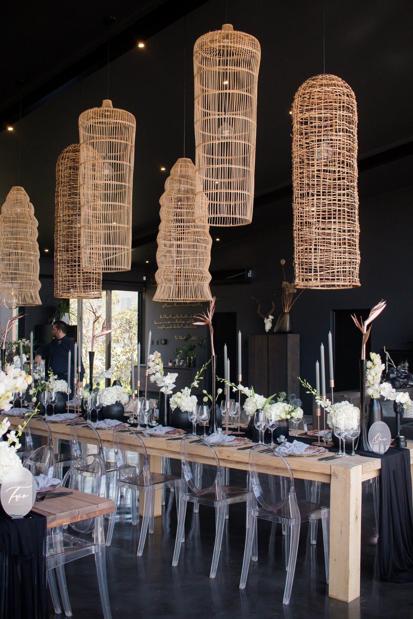 Stylish event space with hanging decor and floral arrangements