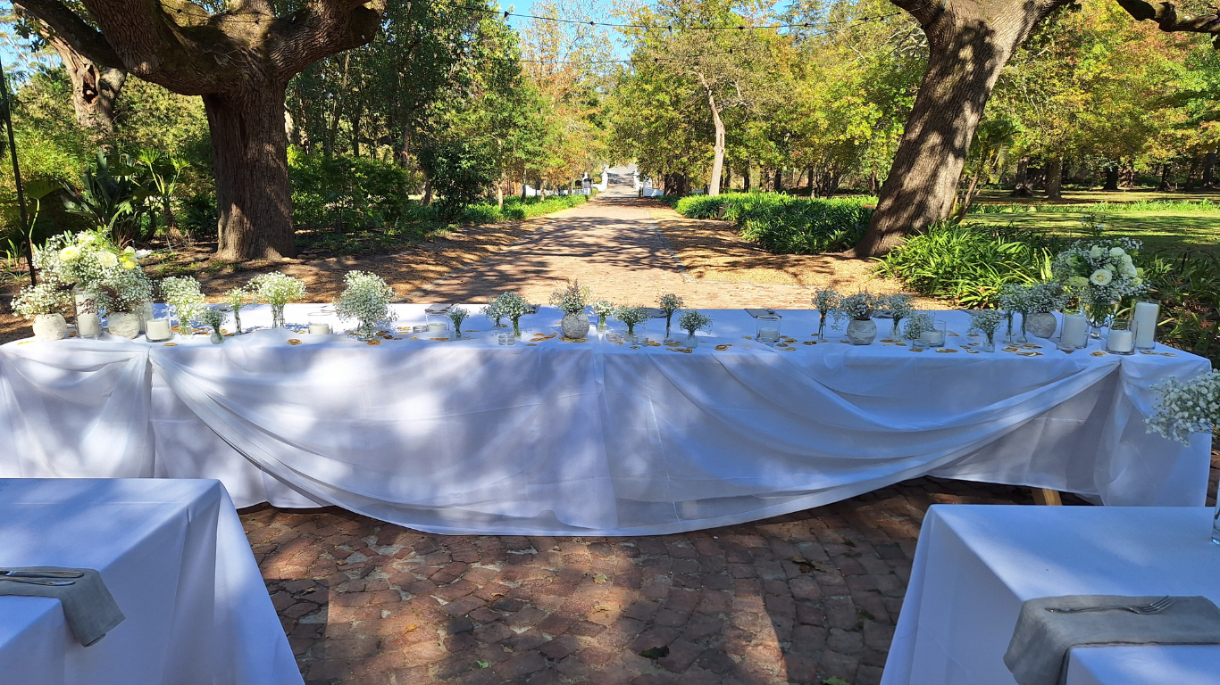 Outdoor table setup with candles and flowers