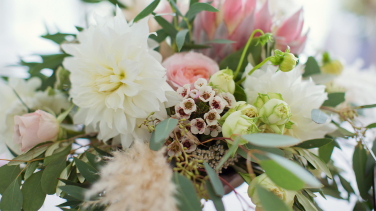 Close-up of a floral arrangement featuring various flowers and greenery.