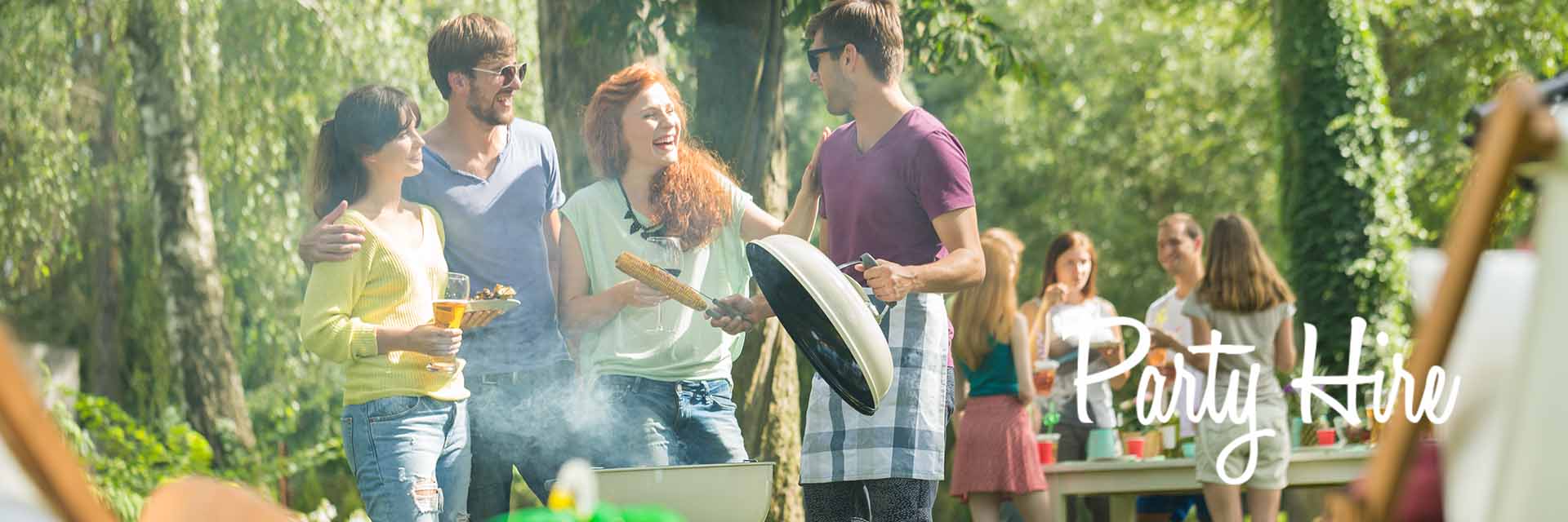 Group enjoying an outdoor gathering with BBQ setup