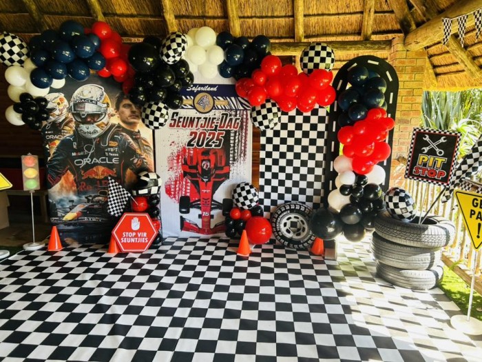 Race-themed decoration with balloons and checkered patterns.
