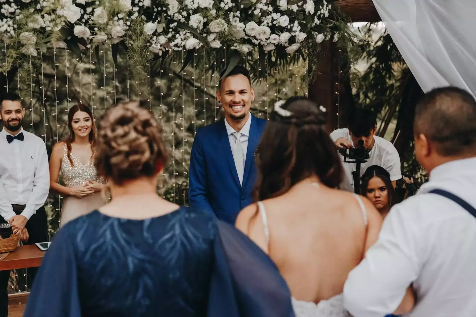 Ceremony scene with guests and a couple exchanging vows under floral decor