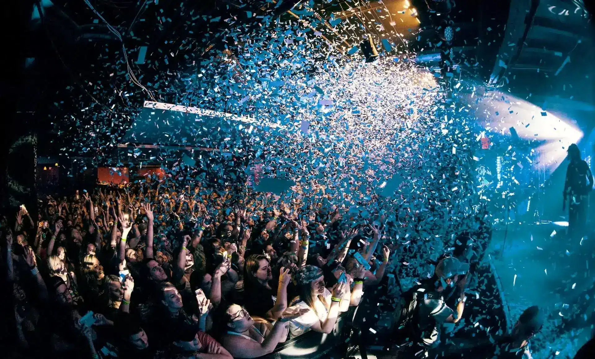 Crowd enjoying a lively event with confetti falling