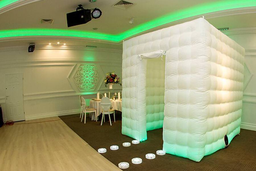 Inflatable photo booth setup with green lighting.