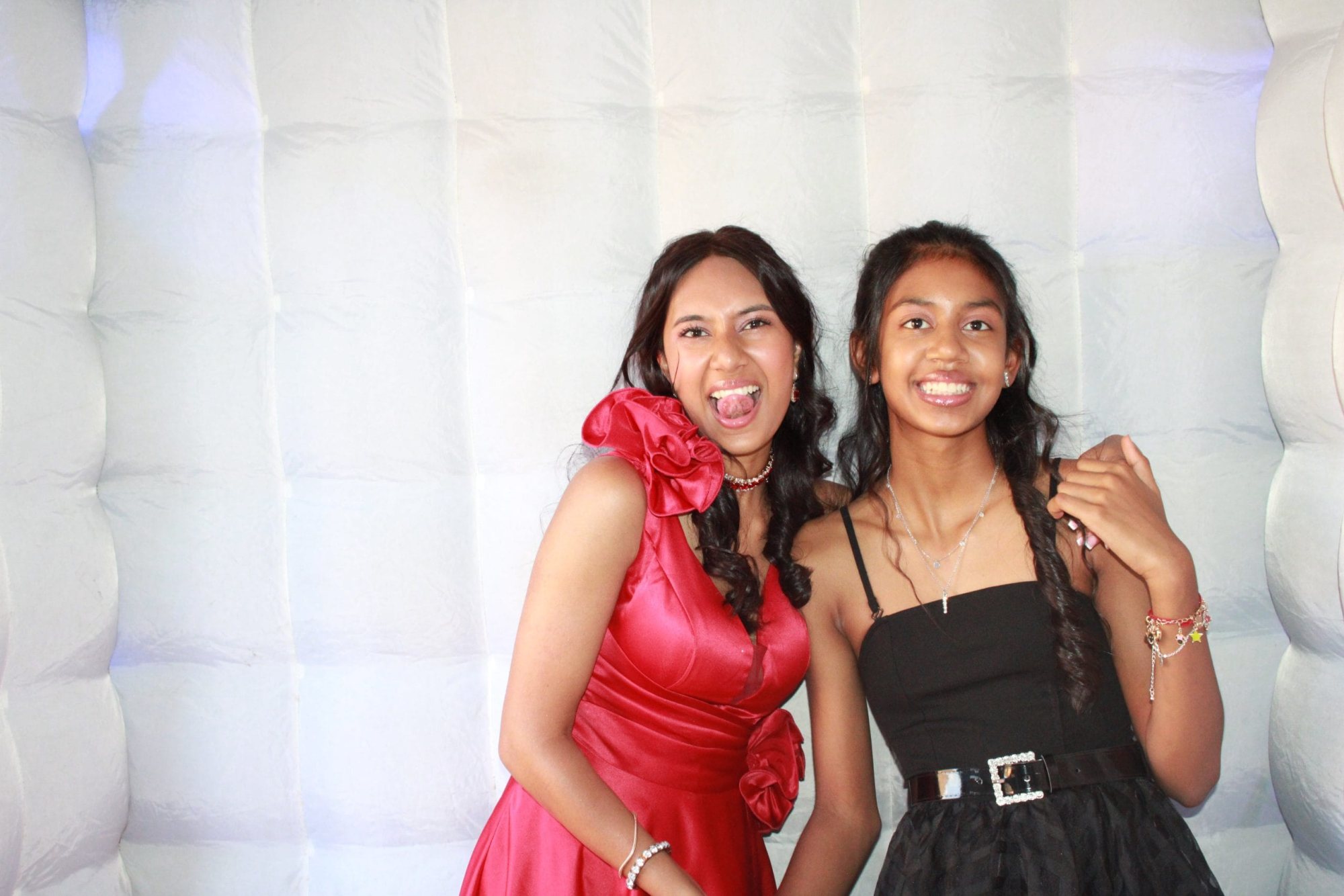 Two smiling women in an inflatable photo booth.