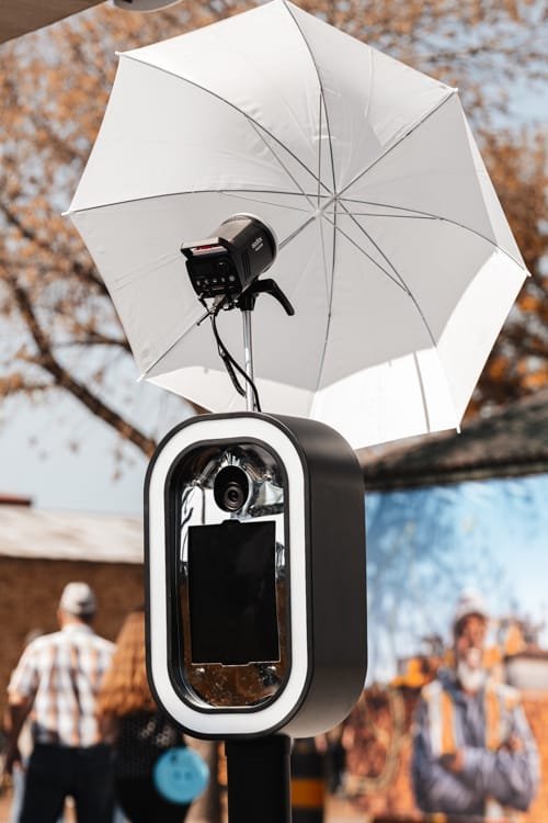 360 video booth with umbrella and camera at an event.