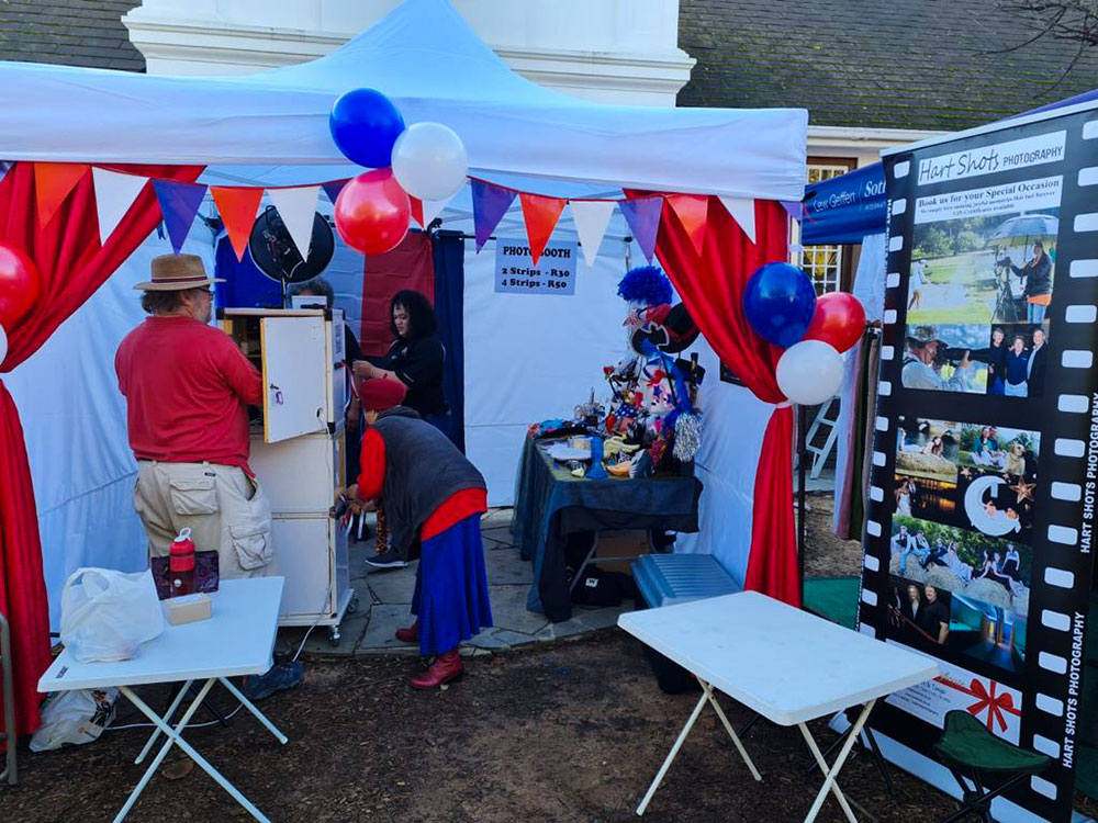 Photo booth setup with red and blue decorations at an outdoor event
