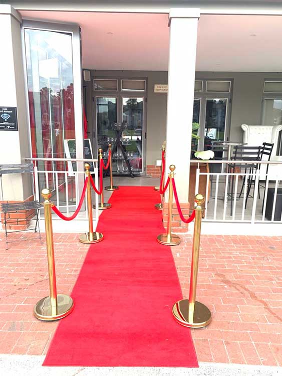 Red carpet setup with gold stanchions and ropes