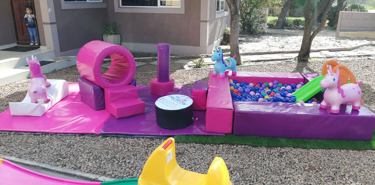 Colorful outdoor soft play area with balls and toys.