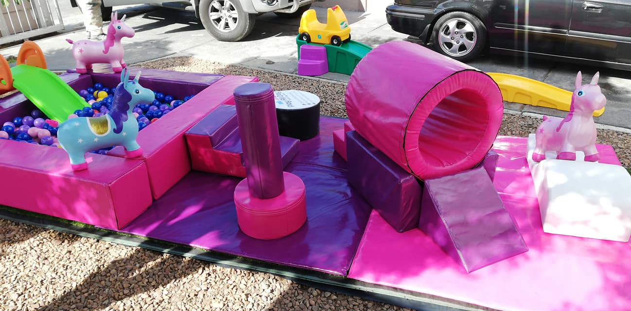 Vibrant purple and pink soft play area with a ball pond and unicorn equipment.