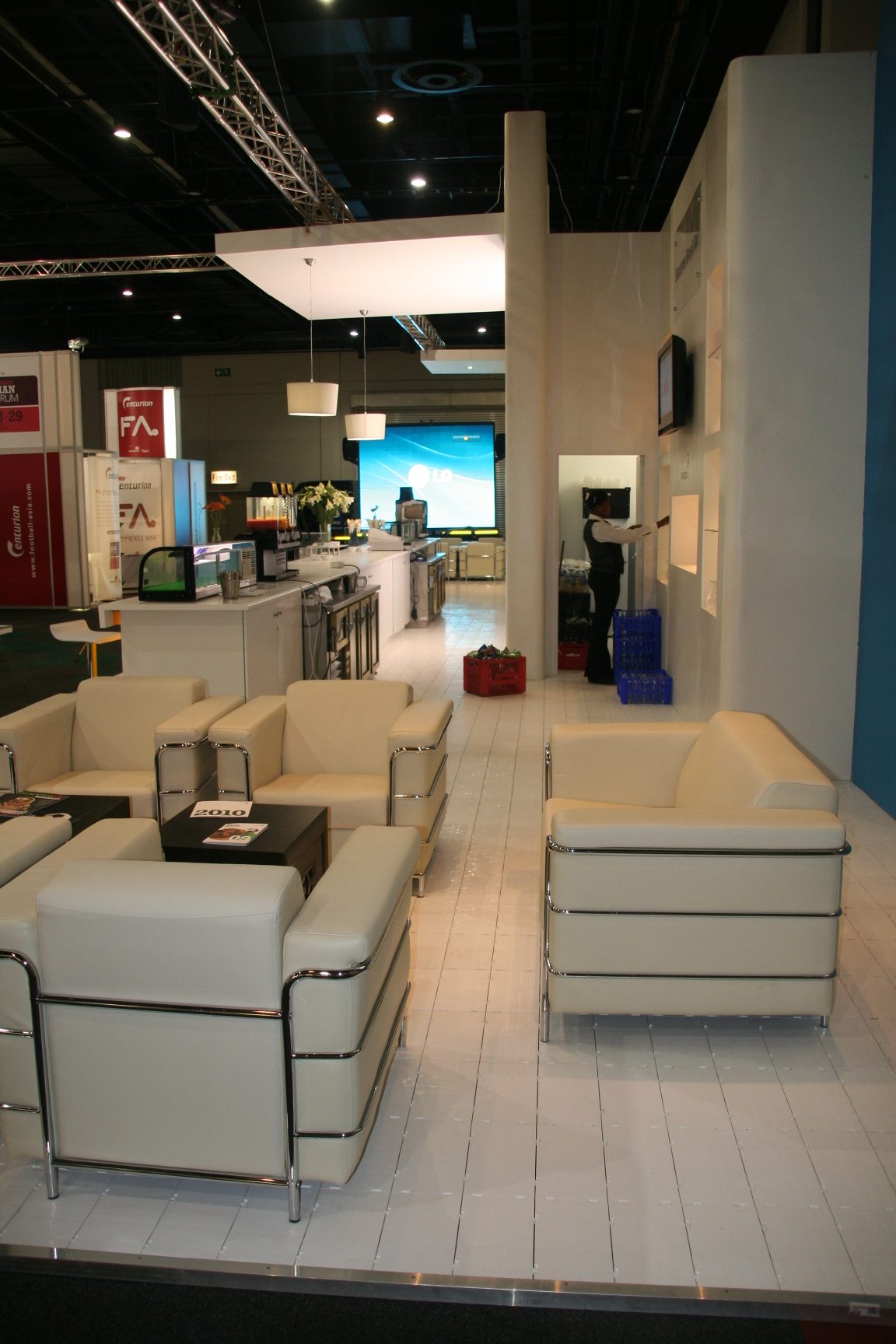 Exhibition booth with cream seating and a black table