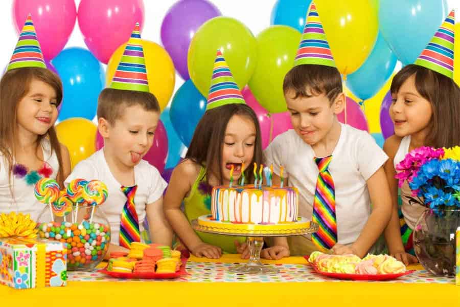 Colorful table setup for a superhero party with balloons and a cake