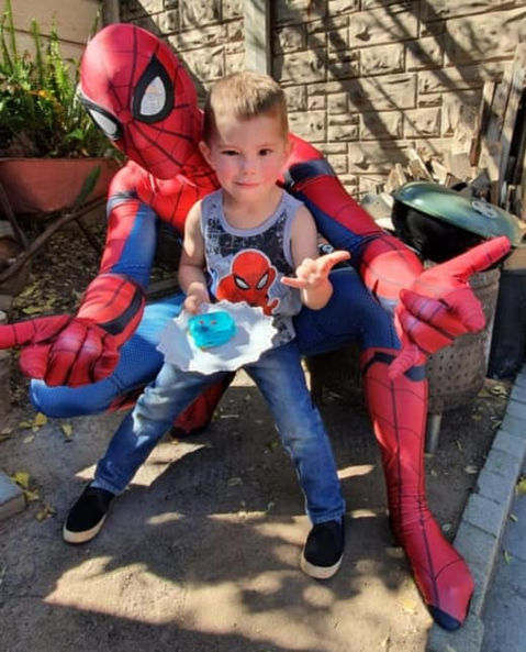 A child with Spider-Man holding a cupcake.