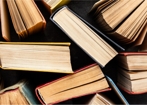 Stacked books representing various printed materials