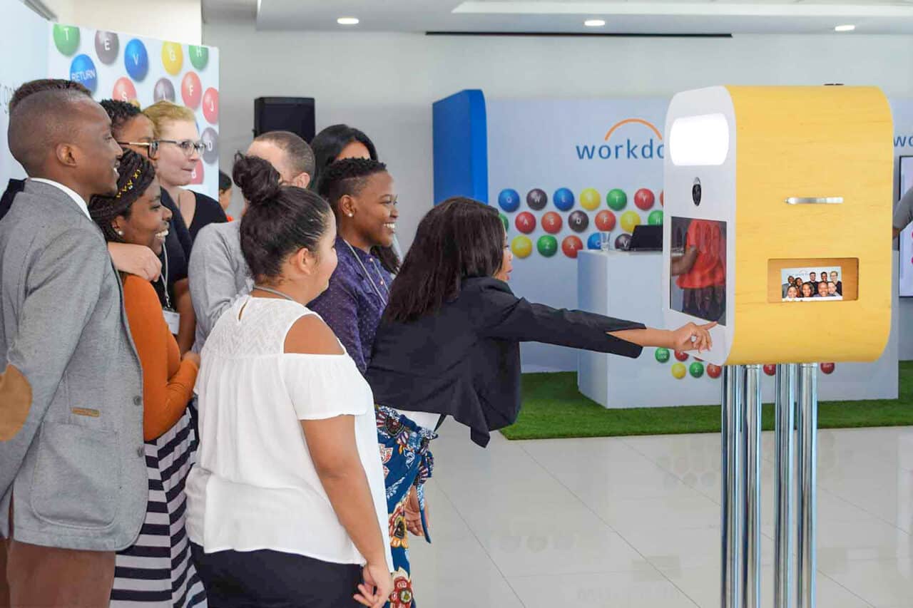 Group of people interacting with a photo booth at an event.