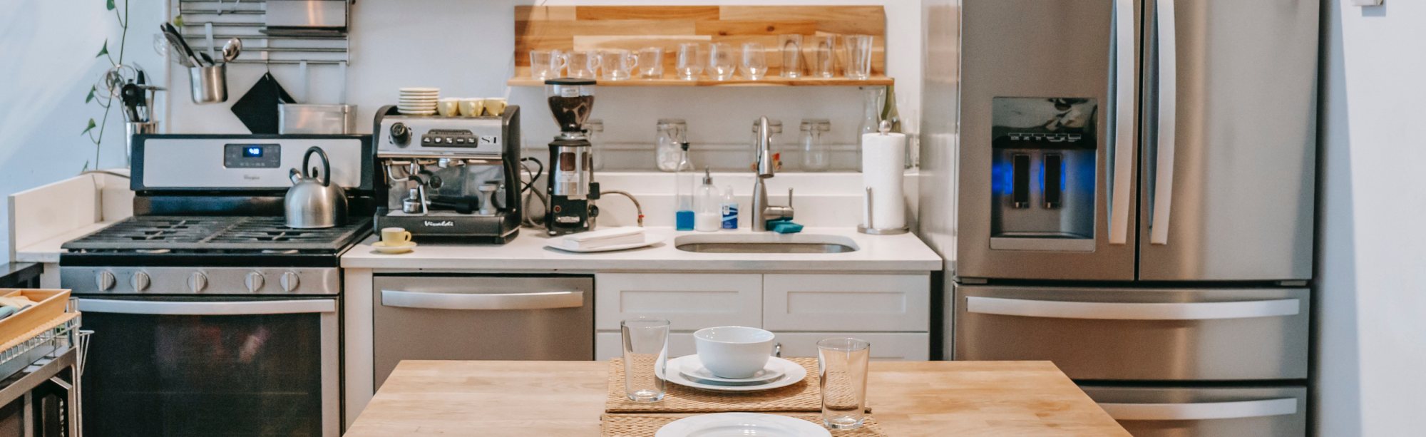 Modern kitchen with appliances and dining setup.
