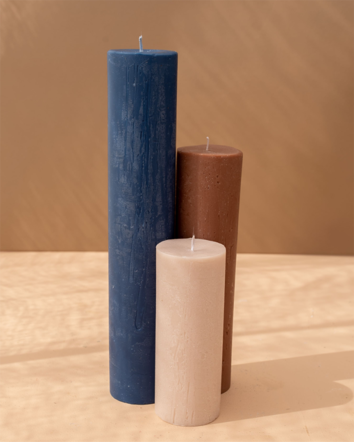 Three hand-poured candles in blue, brown, and beige.