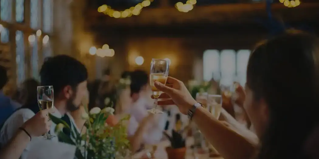 Guests toasting with drinks in a warmly lit indoor venue
